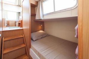 a small room with a bed and a window at Pénichettes itinérantes sans permis - Locaboat in Lattes