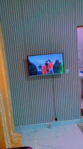 a flat screen tv hanging on a wall with at chambre Dakar tres lix in Ngor