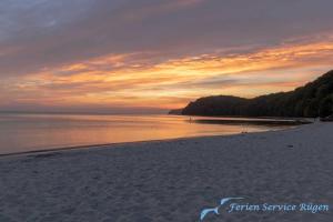 a view of a beach with a sunset in the background at Villa Vogelsang Ferienwohnung 10 "Lachmöwe" in Binz