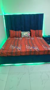 chambre Dakar tres lix في Ngor: سرير مع لحاف احمر ووسادتين