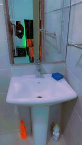 chambre Dakar tres lix في Ngor: بالوعة بيضاء في الحمام مع مرآة