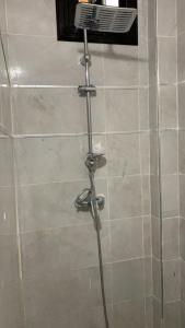 a shower with a shower head in a bathroom at chambre Dakar tres lix in Ngor