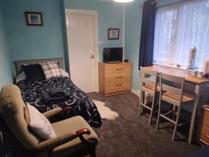 a bedroom with a bed and a desk and a table at Cartmel in Aultbea