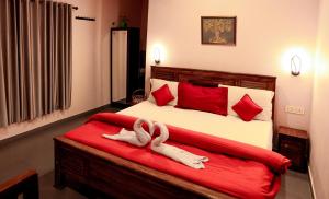 a bedroom with a bed with two towels on it at Aldora Holiday Homes in Vythiri