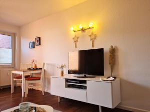 a living room with a television on a white cabinet at Amici JBST 4 Whg Amici in Norderney