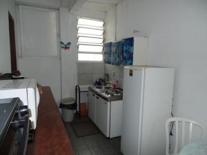 una pequeña cocina con nevera blanca y fregadero en Pousada Centralmar, en Florianópolis