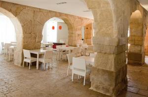a restaurant with white tables and chairs in a stone wall at Boutique Isla Tabarca in Tabarca