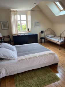 ein Schlafzimmer mit einem großen Bett und einem Fenster in der Unterkunft Villa Tourelle in Dinan