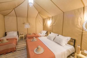 a bedroom with two beds in a tent at Merzouga Heart Luxury Camp in Merzouga