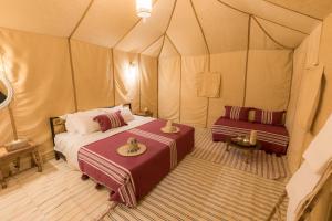 a bedroom with a bed in a tent at Merzouga Heart Luxury Camp in Merzouga