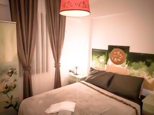 1 dormitorio con 1 cama y lámpara roja en Mandalin Apart 