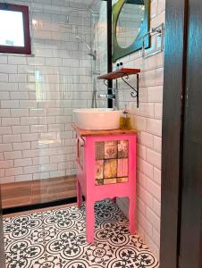 a pink bathroom with a sink and a mirror at Mandalin Apart 