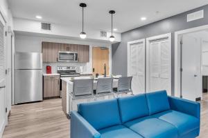 a living room with a blue couch in a kitchen at The Well 206 in Zephyrhills