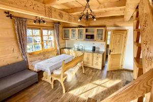 una cocina con mesa en una cabaña de madera en Góralskie Bacówki z widokiem na Giewont, en Zakopane