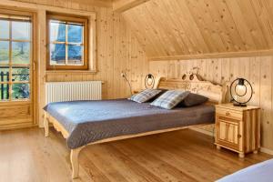 1 dormitorio con 1 cama en una habitación de madera en Góralskie Bacówki z widokiem na Giewont, en Zakopane