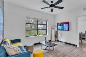 a living room with a blue couch and a ceiling fan at The Well 210 in Zephyrhills
