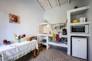 une cuisine avec deux tables et un four micro-ondes dans l'établissement Aimilia Cottage, à Longós