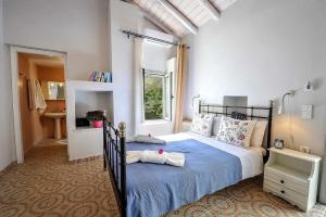 - une chambre avec un lit doté de draps bleus et une fenêtre dans l'établissement Aimilia Cottage, à Longós