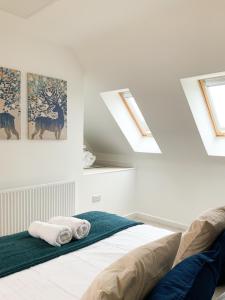 a bedroom with white walls and skylights and a bed at Jockey house in Andover
