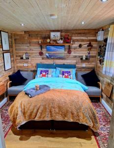 um quarto com uma cama e uma parede de madeira em LILAC COTTAGE cabin em Swafield