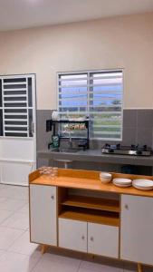 a kitchen with a counter and two windows at Rumah Aidin Homestay in Sitiawan