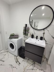 a bathroom with a washing machine and a mirror at Bei den Reymanns in Rheinfelden