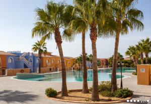 a group of palm trees in front of a swimming pool at VH CostaBlanca - SANDRINE in Benitachell
