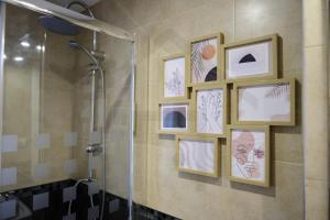 a bathroom with a shower and framed pictures on the wall at Piso Masip in Oviedo