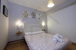 a bedroom with a bed with two towels on it at Piso Masip in Oviedo