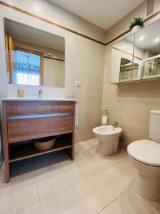 a bathroom with a sink and a toilet and a mirror at Apartamento apto para bebés con parking privado in Almazora