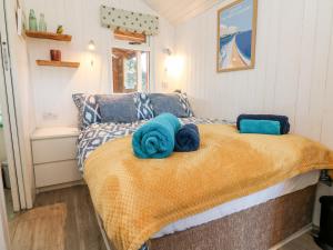 a bedroom with a bed with blue towels on it at Langdale Lodge in Okehampton