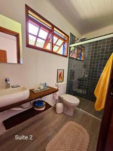 uma casa de banho com um WC com lavatório e um chuveiro em Sítio O Gajo em São Luiz do Paraitinga