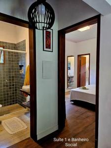 Habitación con baño con ducha y dormitorio. en Sítio O Gajo en São Luiz do Paraitinga