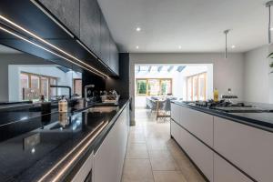 a kitchen with black countertops and a dining room at SandiComplex - 2 properties joined by a garden gate in Sandwich