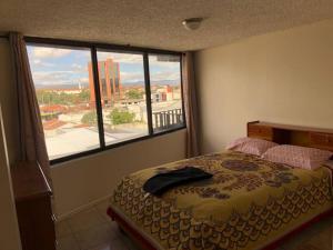 a bedroom with a bed and a large window at Mirador del Estadio in Cuenca