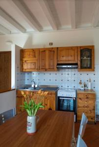 cocina con armarios de madera y mesa de madera en Casa vacanze Rasetto, en Costa di Mezzate