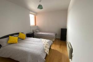 Un dormitorio con una cama con almohadas amarillas. en Vera’s Penthouse en Wexford
