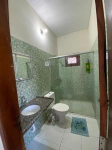 a bathroom with a toilet and a sink and a shower at Casa Temporada in Parnaíba