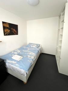 Cozy, bright room with free parking في براتيسلافا: غرفة نوم صغيرة مع سرير ورف
