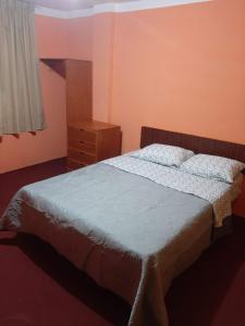 ein Schlafzimmer mit einem Bett, einer Kommode und einem Fenster in der Unterkunft Villa el sol in Cajamarca