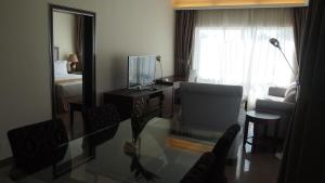 a living room with a glass table and a bedroom at Plaza Hotel in Dili