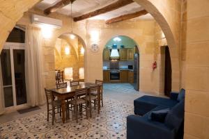 a kitchen and dining room with a table and chairs at SurWig Vacation Townhouse in Kerċem