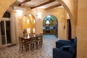 a kitchen and dining room with a table and chairs at SurWig Vacation Townhouse in Kerċem