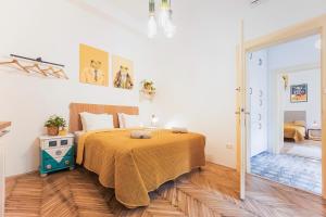 um quarto com uma cama com uma colcha laranja em BudapeStayz - Lónyay Studios em Budapeste