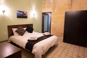 a bedroom with a bed with towels on it at SurWig Vacation Townhouse in Kerċem