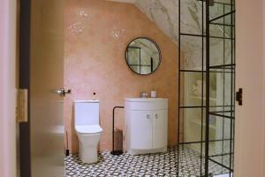 un baño con inodoro y espejo en Stunning Coach House, en Largs 23 fotos más