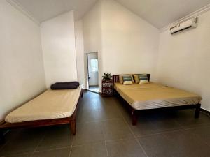 Habitación con 2 camas en una habitación en A Maze Inn Cottage en Phumĭ Chroŭy Svay