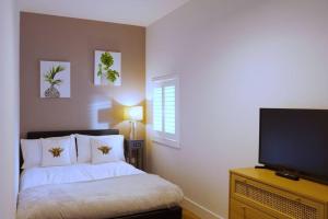 Un dormitorio con una cama y un televisor de pantalla plana. en Stunning Coach House, en Largs