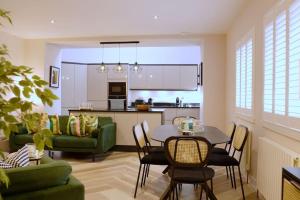 a living room with a table and a green couch at Stunning Coach House in Largs