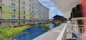 a view of a hotel courtyard with a swimming pool at JC SpaceRentals 127B Amani Grand Resort Residences, balcony pool view, Ground floor, 5 mins frm airport, free wifi, Netflix in Pusok